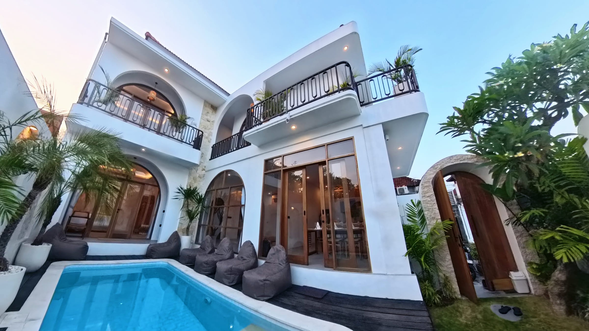 White villa with arched balconies, a private pool and bean-bag loungers at Casa Aurea