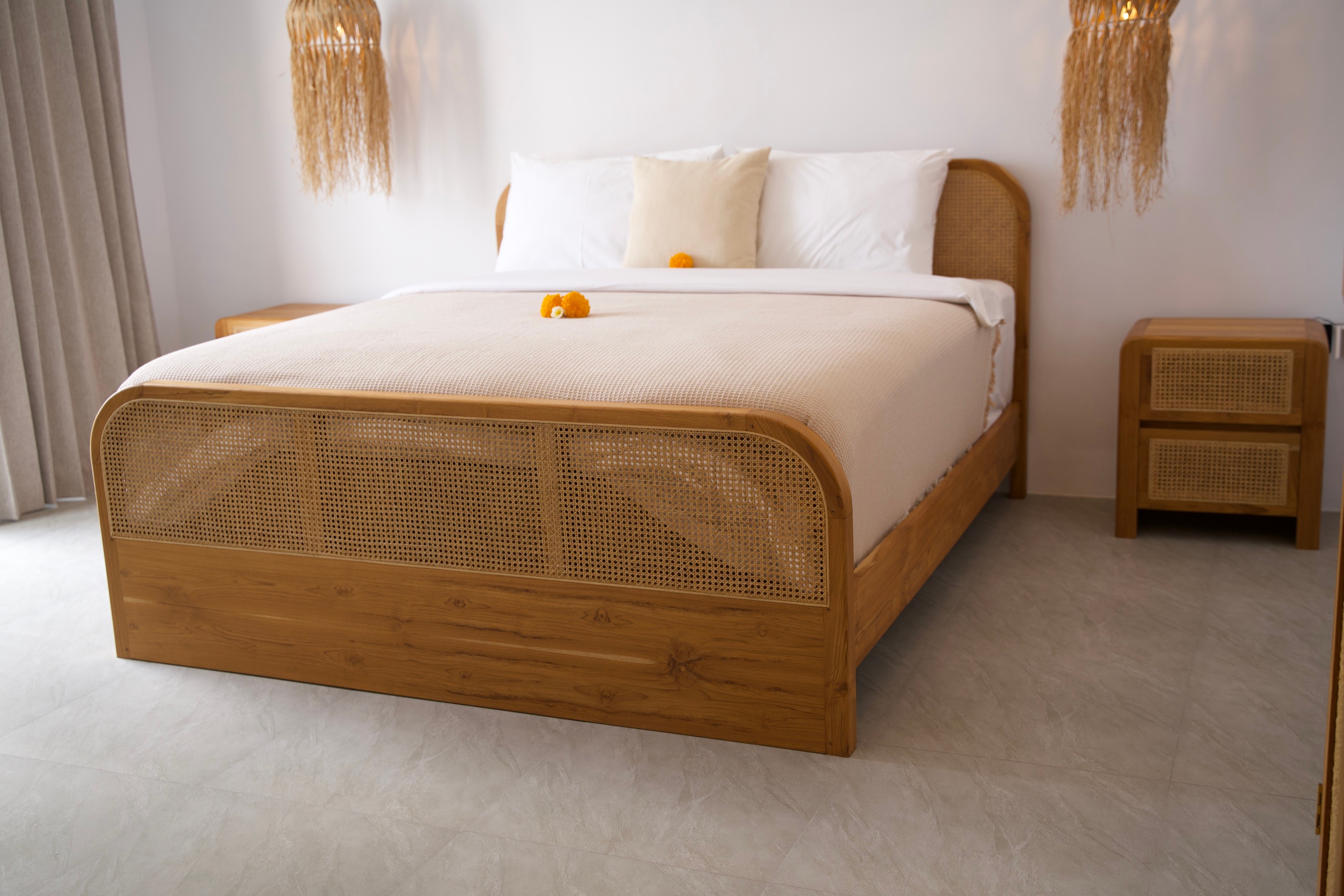 Bedroom with rattan bed and woven pendant lamps at Casa Aurea