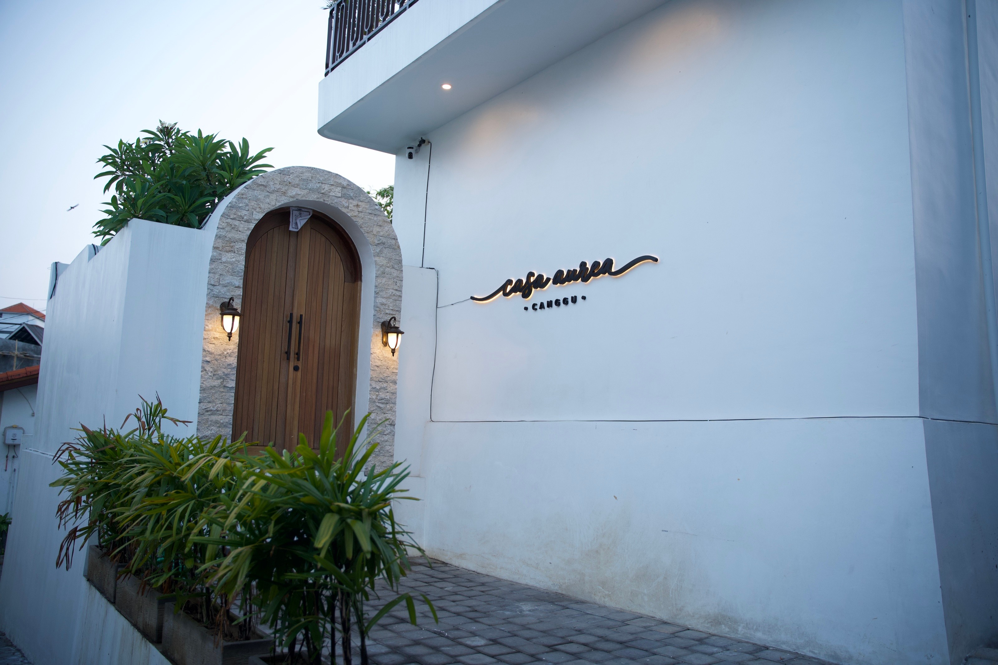 Casa Aurea entrance with arched wooden door and illuminated signage