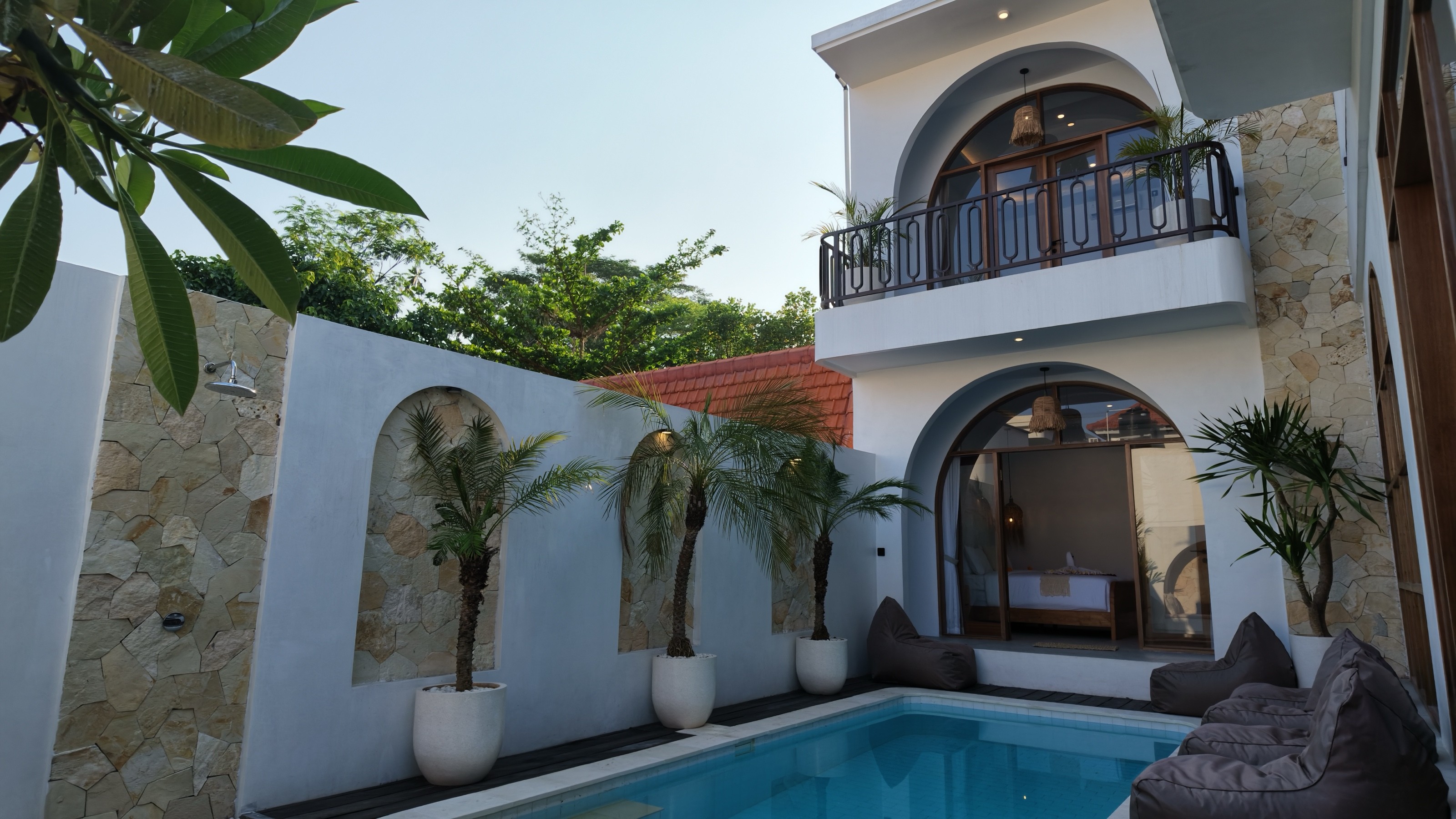 Private swimming pool surrounded by white arched architecture at Casa Aurea